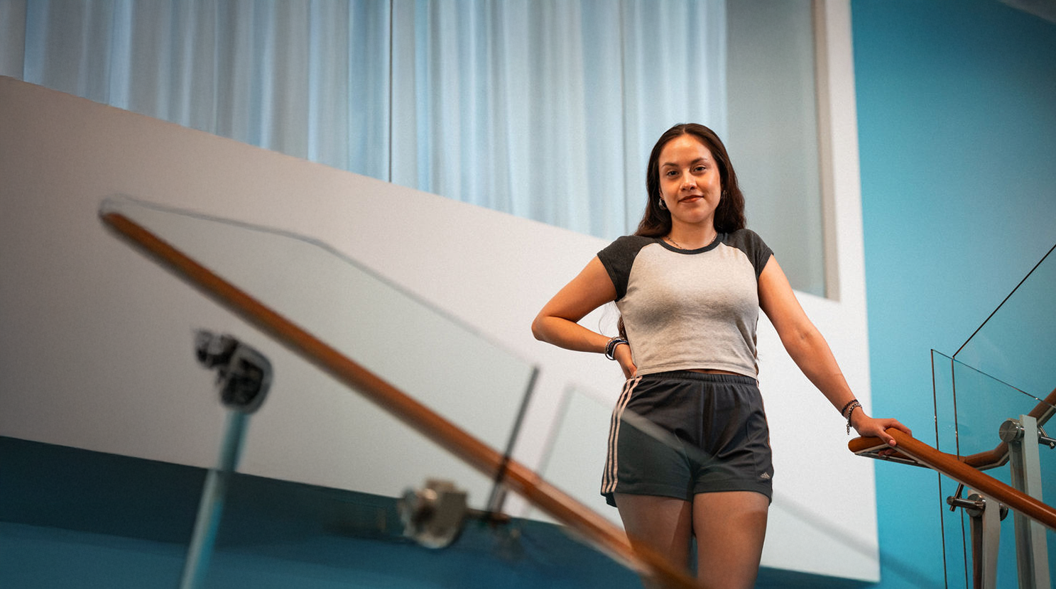An Adler University student stands near a staircase at the Chicago Campus.